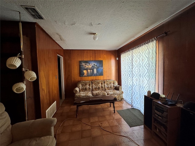 sitting room with wooden walls and a textured ceiling