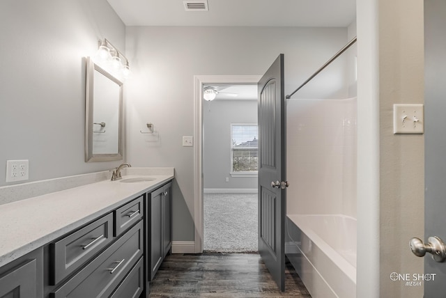 bathroom featuring wood-type flooring, vanity, ceiling fan, and bathing tub / shower combination