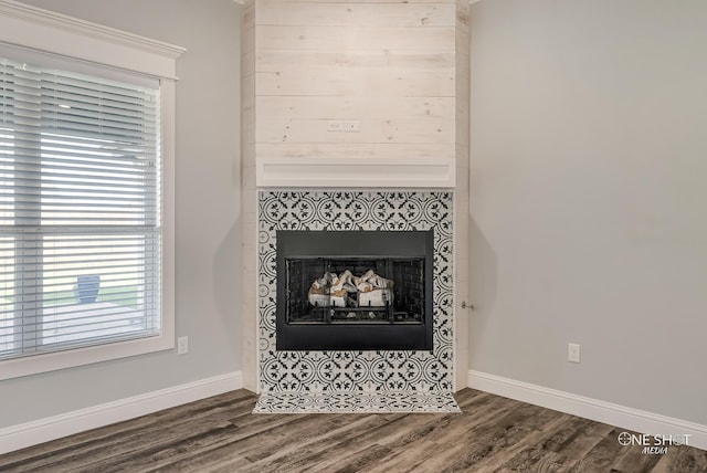 interior details with a tile fireplace and hardwood / wood-style flooring