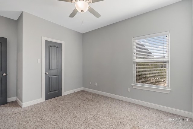 empty room with ceiling fan, plenty of natural light, and carpet flooring