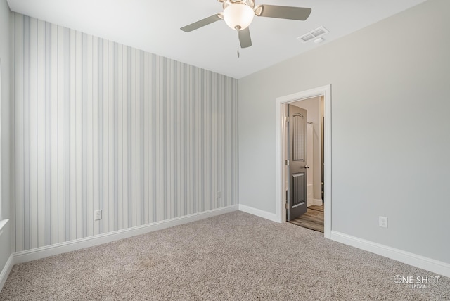 carpeted spare room with ceiling fan