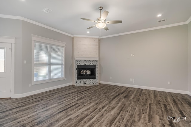 unfurnished living room featuring ceiling fan, dark hardwood / wood-style flooring, ornamental molding, and a tile fireplace