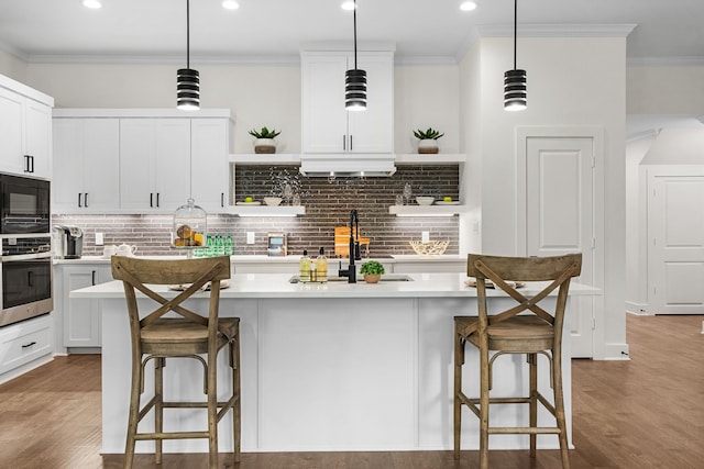 kitchen featuring oven, a kitchen bar, pendant lighting, and a kitchen island