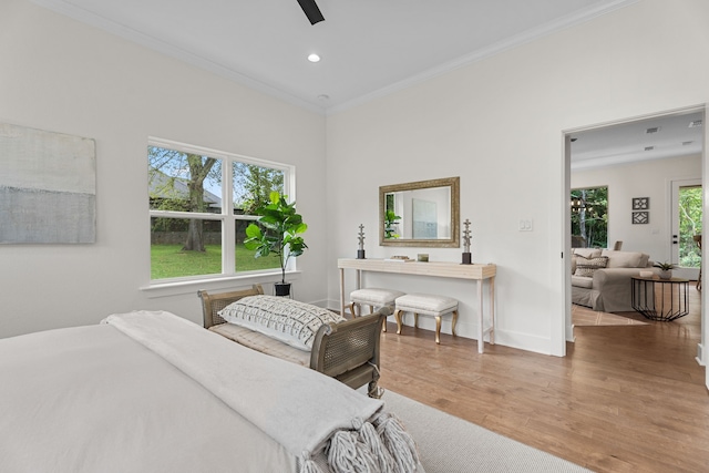 bedroom featuring ceiling fan, ornamental molding, and wood-type flooring