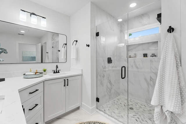 bathroom with a shower with door and vanity