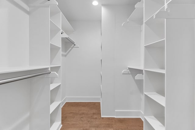 walk in closet with hardwood / wood-style flooring