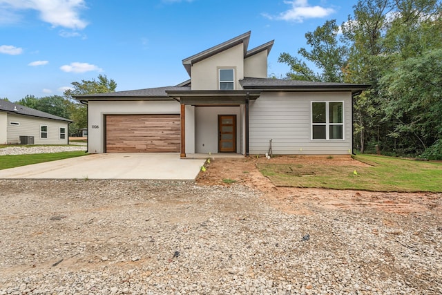 view of front of house with a garage and central AC