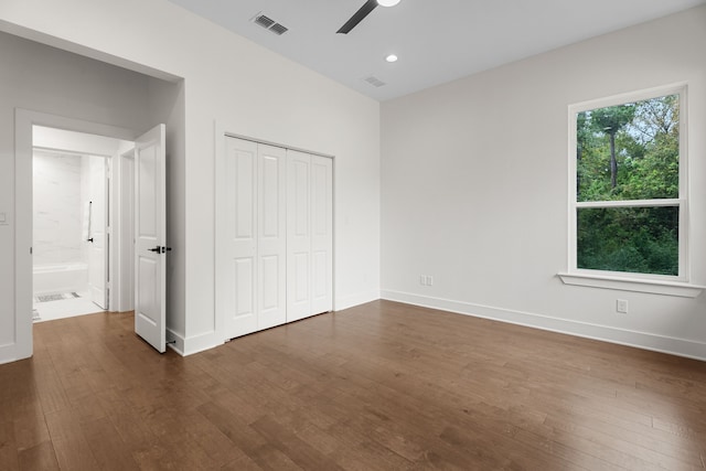 unfurnished bedroom with a closet, ceiling fan, and dark wood-type flooring