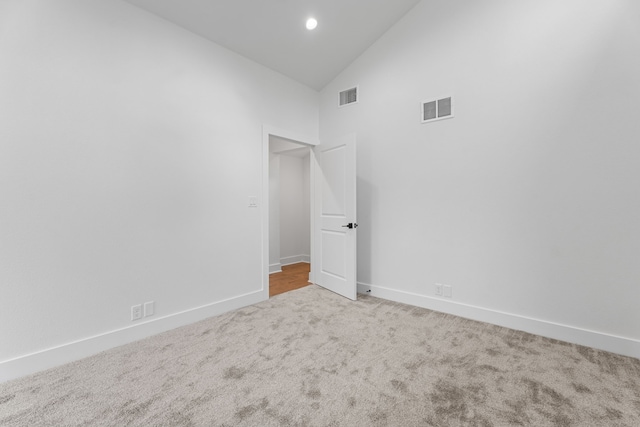 unfurnished room with high vaulted ceiling and carpet