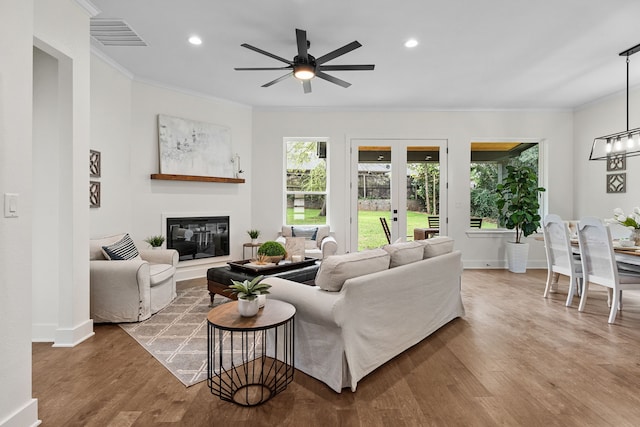 living room with hardwood / wood-style flooring, french doors, ceiling fan, and crown molding