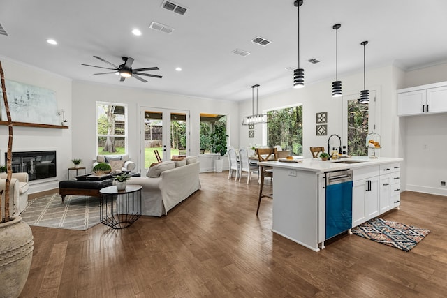 kitchen with sink, a center island with sink, stainless steel dishwasher, and white cabinetry