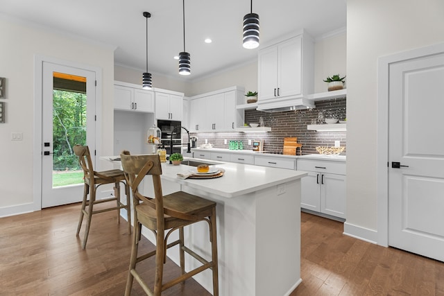 kitchen featuring decorative light fixtures, white cabinetry, decorative backsplash, a wealth of natural light, and black appliances