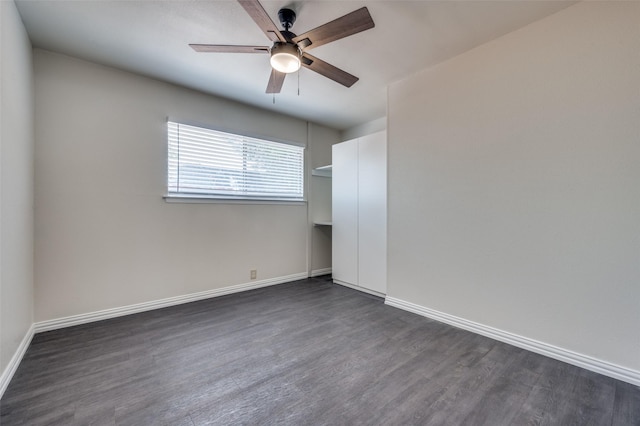 spare room with dark hardwood / wood-style flooring and ceiling fan