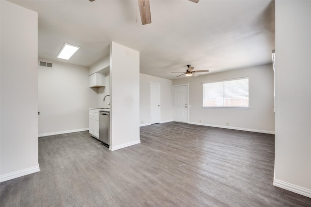 unfurnished living room featuring sink, ceiling fan, and dark wood-type flooring