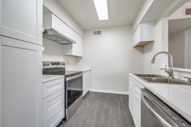 kitchen featuring white cabinets, stainless steel appliances, light wood-type flooring, and sink