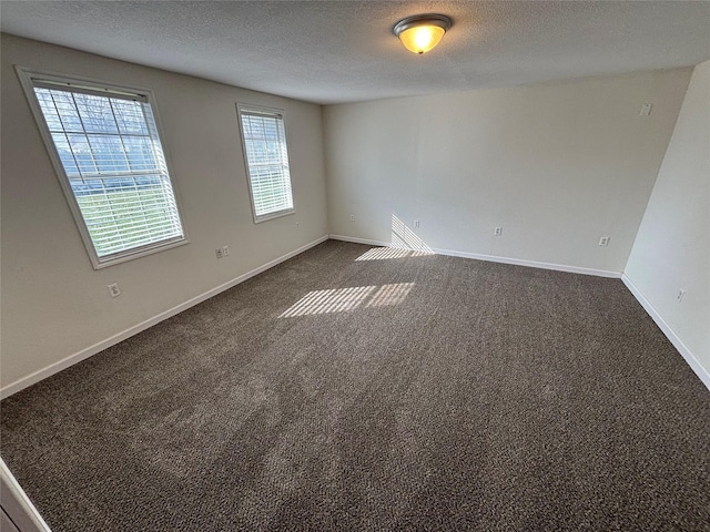 carpeted empty room featuring a textured ceiling