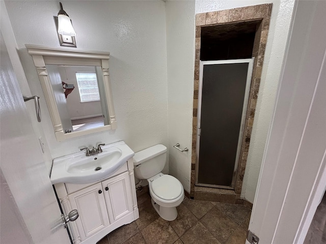 bathroom with toilet, an enclosed shower, and vanity