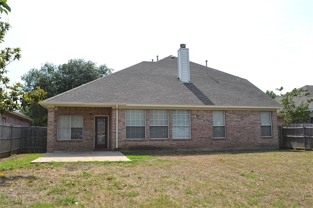 rear view of house featuring a lawn and a patio area