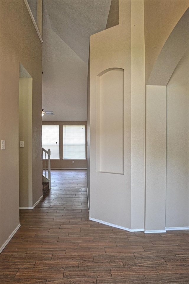 hallway featuring dark hardwood / wood-style flooring and high vaulted ceiling