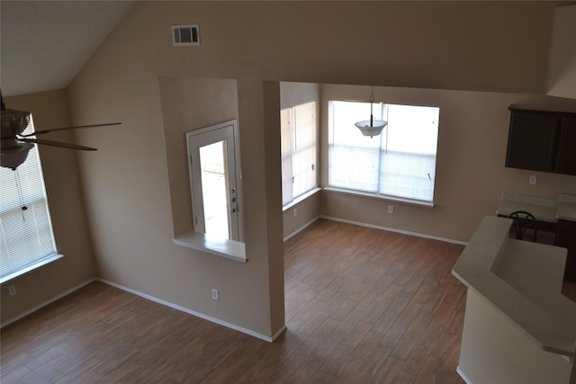 unfurnished living room featuring ceiling fan, dark wood-type flooring, and lofted ceiling