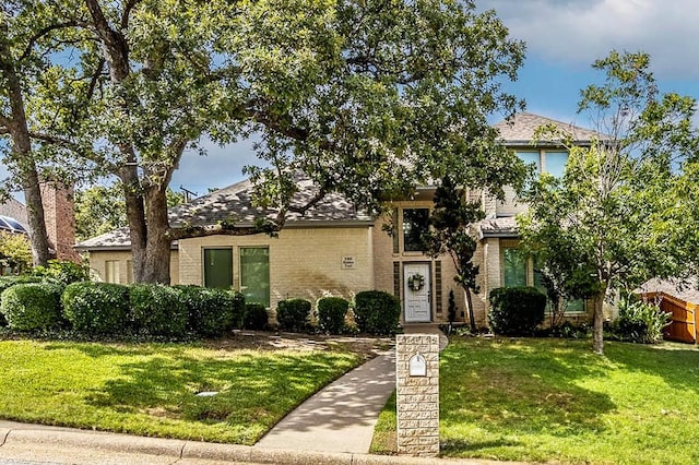 obstructed view of property with a front lawn