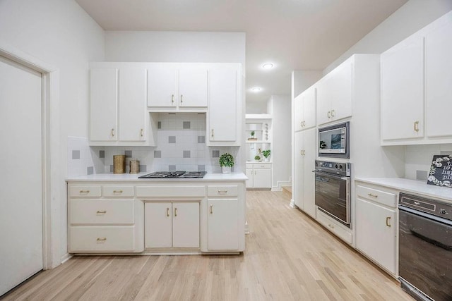 kitchen with stainless steel appliances, light wood-type flooring, decorative backsplash, and white cabinetry