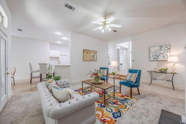 living room featuring ceiling fan and light colored carpet