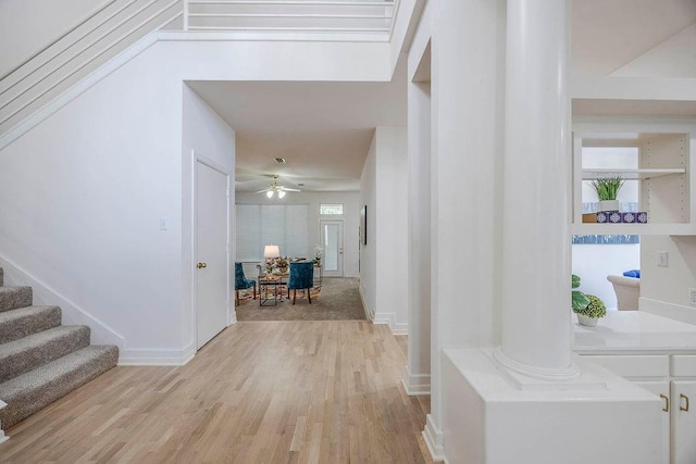 hallway with decorative columns and light hardwood / wood-style flooring