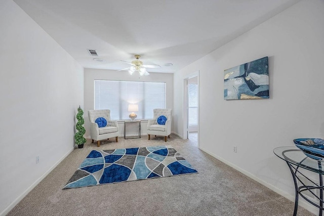 sitting room with ceiling fan and carpet