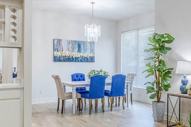 dining area with a notable chandelier, a healthy amount of sunlight, and light wood-type flooring