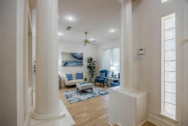 living room with ceiling fan, decorative columns, and hardwood / wood-style flooring