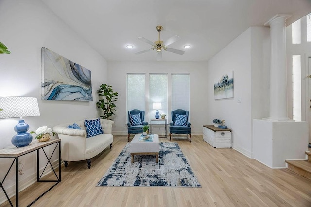 living area featuring decorative columns, ceiling fan, and light hardwood / wood-style flooring