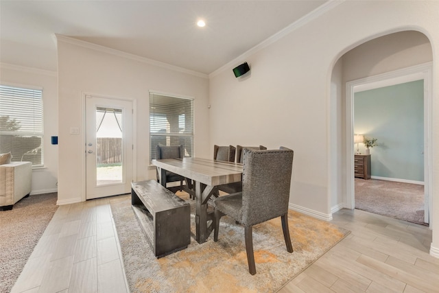 carpeted dining space featuring ornamental molding