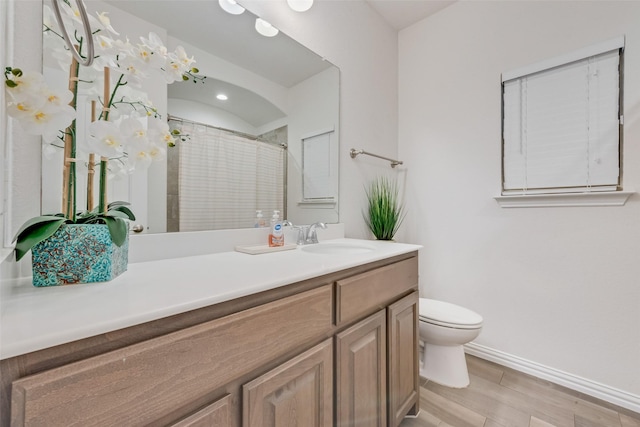 bathroom featuring toilet, vanity, and walk in shower