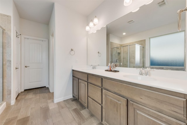 bathroom with a shower with door and vanity