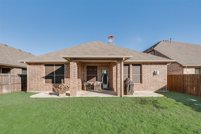 back of property with a yard and a patio area