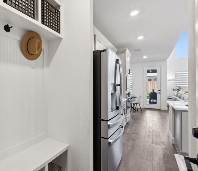 kitchen with stainless steel appliances, dark hardwood / wood-style flooring, and white cabinets