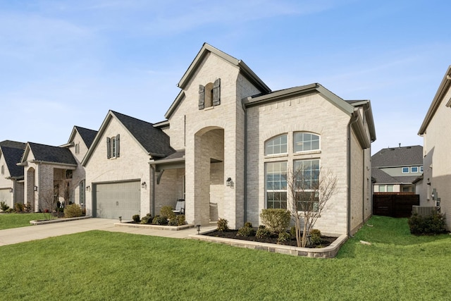 french country home with a front yard and a garage