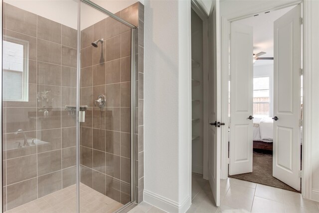 bathroom featuring ceiling fan, an enclosed shower, and tile patterned floors