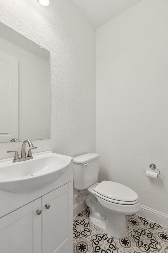 bathroom featuring toilet, tile patterned flooring, and vanity