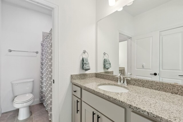 bathroom featuring vanity, a shower with shower curtain, tile patterned flooring, and toilet