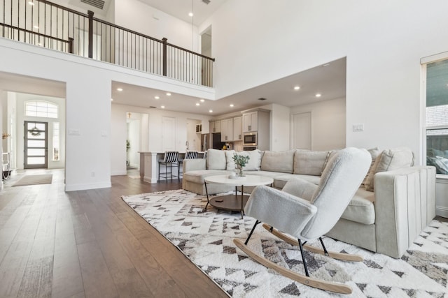 living room with a high ceiling and light hardwood / wood-style floors