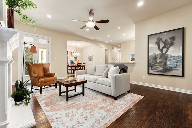 living room featuring ceiling fan with notable chandelier and hardwood / wood-style flooring