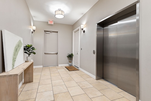 hallway with elevator and light tile patterned flooring