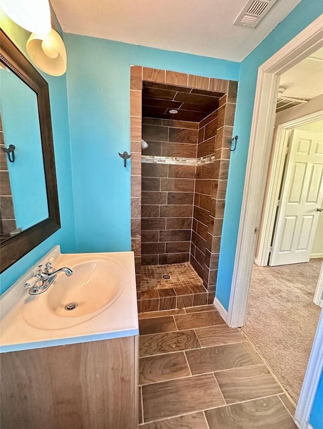 bathroom with vanity and tiled shower