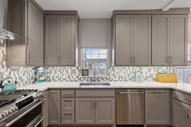 kitchen featuring sink, appliances with stainless steel finishes, backsplash, and gray cabinets