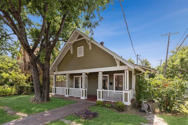 bungalow featuring a porch and a front lawn