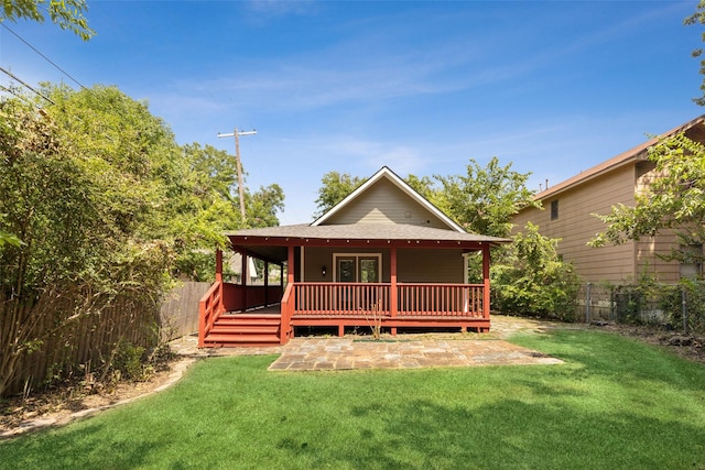 rear view of house featuring a yard and a deck