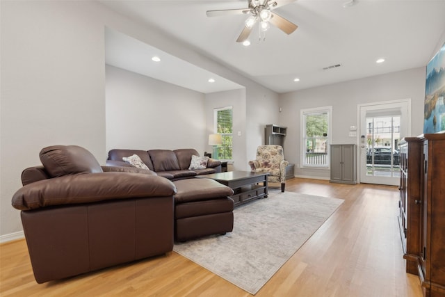 living room with light hardwood / wood-style floors and ceiling fan