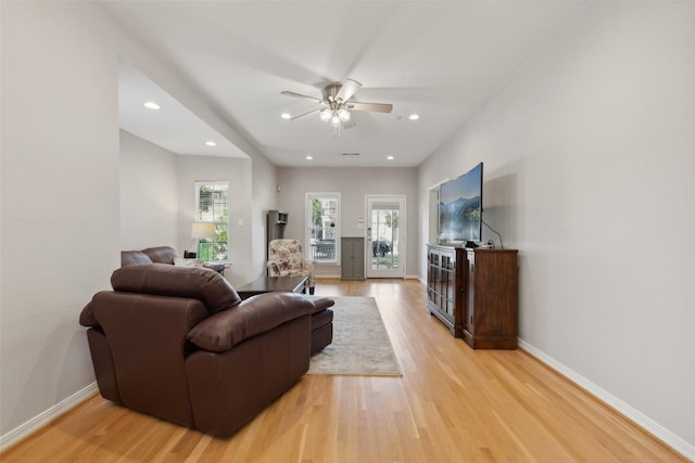 living room featuring ceiling fan and light hardwood / wood-style floors